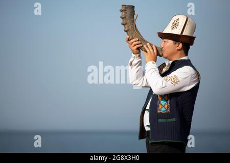 Kirgisischer Musiker, der in Issyk Kul, Kirgisistan, traditionelles lokales Instrument spielt. Stockfoto