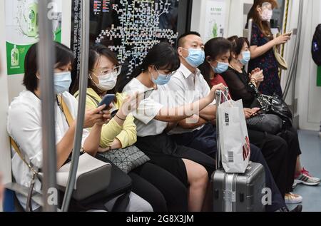 Menschen, die Gesichtsmasken tragen, nutzen in Peking eine Straßenbahn als vorbeugende Maßnahme. Am Donnerstag, dem 22. Juli 2021, sagte ein hochrangiger chinesischer Gesundheitsbeamter, dass China den Plan der Weltgesundheitsorganisation für die zweite Phase einer Studie über die Ursprünge des COVID-19 nicht akzeptieren kann. Stockfoto
