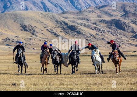 Nomad Reiter spielen traditionelles Pferd Spiel von Buzkashi auch bekannt als Kokpar, in Issyk Kul, Kirgisistan. Stockfoto