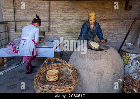 Usbekische Frauen, die in Chiwa, Usbekistan, Tandoori-Brot backen. Stockfoto