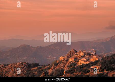 Abendsonne auf dem alten Bergdorf Speloncato in der Balagne auf Korsika mit Cap Corse in der Ferne Stockfoto