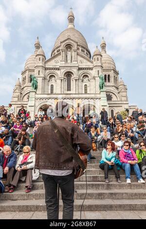 Eine Menge Touristen versammelten sich am Fuße der Basilika des Heiligen Herzens von Montmartre in Paris Stockfoto