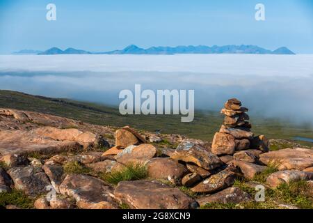 Eine Wolkeninversion der fernen Cuillin Ridge Berge auf der Insel Skye, Schottland, vom Gipfel des Bealach Na Ba bei Applecross aus gesehen Stockfoto