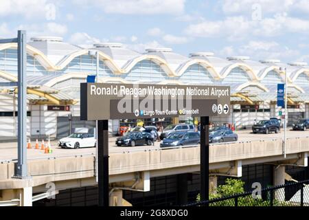 ARLINGTON VA, USA - 13. Jul 2021: Das Washington National Airport Schild nach Ronald Reagan mit Flughafenterminal im Hintergrund Stockfoto