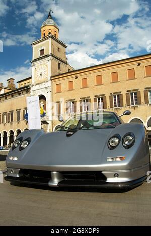 01-07-2021, Modena - Italien. Motor Valley Cars Ausstellung, grau Pagani Zonda auf der Piazza Grande mit dem Stadtuhrturm. Konzept für italienischen Stil, Luxus Stockfoto