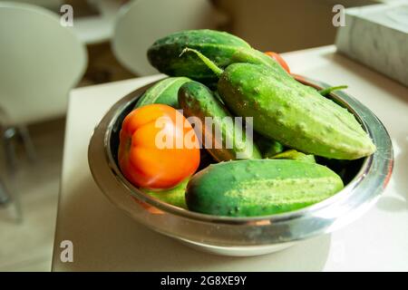 Frische Tomaten und Gurken in einer Schüssel, Sommertag Stockfoto