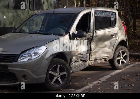 Auto nach einem Unfall. Transport defekt. Ein zerschlagene Auto auf der Straße. Zerknittertes Eisen. Kaputtes graues Auto. Stockfoto