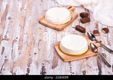 Vanillepanna Cotta mit Karamell auf rustikalem Holztisch. Italienisches Dessert mit gesüßter Creme, mit Gelatine verdickt Stockfoto