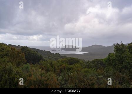 Blick von der Zufahrtsstraße über die Lighthouse Bay zum Cape Bruny (Island) Lighthouse, einem denkmalgeschützten Gebäude aus dem Jahr 1836 an einem regnerischen Tag Stockfoto