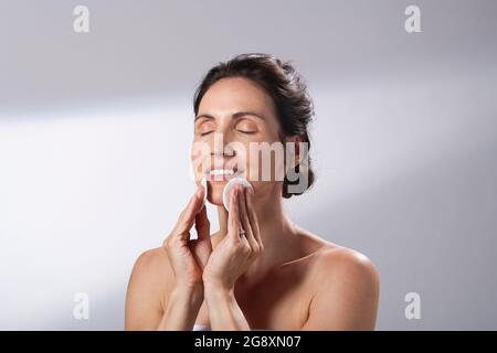 Eine Frau, die ein Paar Wattepads verwendet. Reinigt ihr Gesicht. Stockfoto