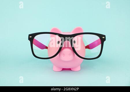 Rosa Sparschwein trägt eine Brille. Sparkonzept Stockfoto