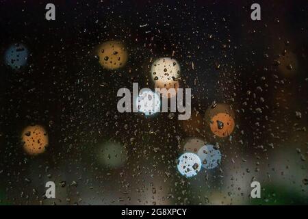 Wassertropfen, Lichter der Stadt auf dem Glas in der Nacht, Bokeh, Hintergrund Stockfoto