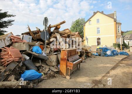 Bad Neuenahr Ahrweiler, Deutschland. Juli 2021. Berge von sperrigen Abfällen häufen sich am Straßenrand meters hoch, davor steht ein Klavier. Die Reinigungsarbeiten im überfluteten Bereich sind in vollem Gange. Kredit: Bodo Marks/dpa/Alamy Live Nachrichten Stockfoto