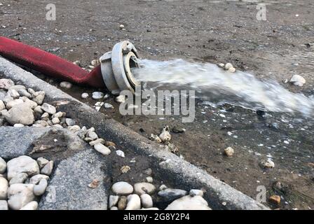 Wasserschaden - Wasser wird nach heftigen Regenfällen aus einem überfluteten Keller in Köln gepumpt. Stockfoto