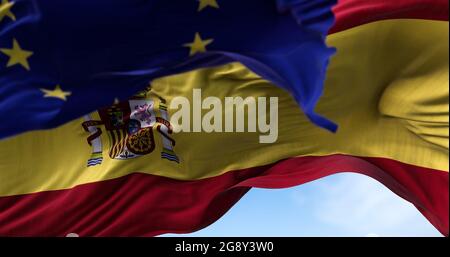 Die im Wind winkende Nationalflagge Spaniens sowie die Flagge der Europäischen Union verschwimmen im Vordergrund. Politik und Finanzen. Spanien ist Mitglied Stockfoto