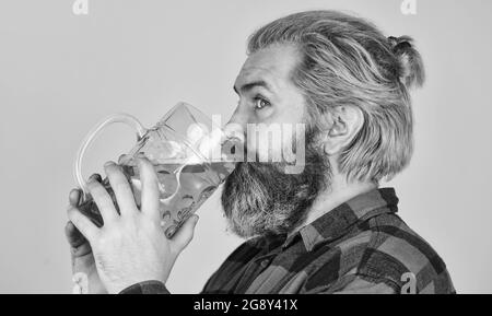 Handwerkliche Bierindustrie. Bierkneipe. Stilvoller Barkeeper oder Barkeeper in der Bar. Erholung. Mann hält ein Glas Bier. Hipster an der Theke. Spaß beim Zuschauen Stockfoto