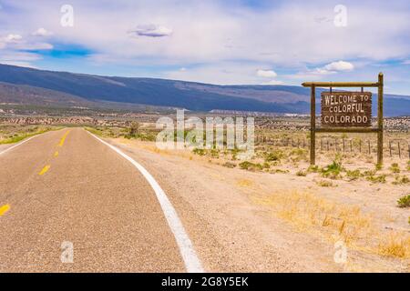 Willkommen zum farbenfrohen Colorado-Schild entlang einer langen Straße an der Grenze zwischen Colorado und Utah. Stockfoto