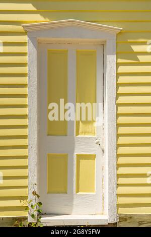 Alte weiße und gelbe Tür an der Außenseite des Klapptafel-Hauses Stockfoto