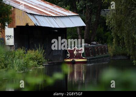 Ein Narrowboot, das am alten Bootshaus auf dem wunderschönen Basingstoke Canal in Ash-Pale in Surrey festgemacht ist Stockfoto