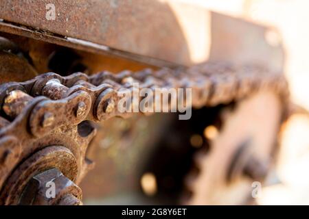 Rostige Details von alten verlassenen Autos. Zahnräder, Ketten, Riemenscheiben rosten im offenen Bereich. Moosbedeckte Metallteile von Landmaschinen. Stockfoto