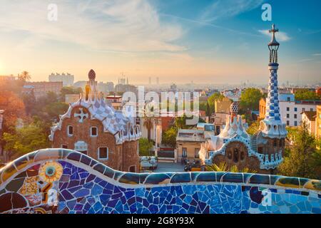 Blick auf die Stadt Barcelona vom Parc Güell. Blick auf das farbenfrohe Mosaikgebäude im Park Güell bei Sonnenaufgang Stockfoto