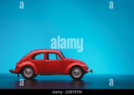 Izmir, Türkei - 16. April 2021: Nahaufnahme einer Seitenansicht Rot gefärbter Volkswagen Käfer Spielzeugwagen auf blauem Hintergrund. Stockfoto