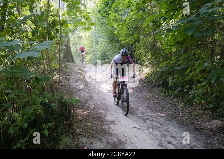 Zwei Männer auf Mountainbikes auf staubiger Straße während des MTB-Radmarathons in Sigulda, Gauja Nationalpark, Lettland Stockfoto