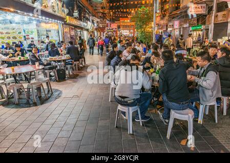 Hongkong - 15. Dezember 2016: Abends sitzen Menschen in den Straßencafés im Central City District. Stockfoto