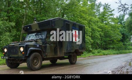 Eine britische Armee Defender 130 Battle Field Ambulance in Aktion bei einer militärischen Übung, Wiltshire UK Stockfoto