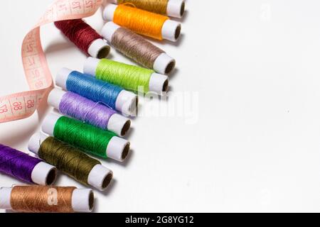 Maßband und weiße Fäden mit Platz für den Text des Banners. Für den Arbeiter-Werkstatt, Näherin, Nähwerkstatt Stockfoto