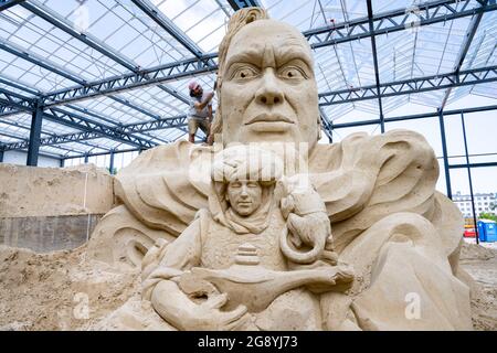 Prora, Deutschland. Juli 2021. Auf dem Gelände des Sandskulpturen-Festivals auf Rügen arbeitet ein Mann an einer großen Sandfigur aus dem Märchen 'Aladdin und die magische Lampe'. Für die Sandskulpturen-Schau, die am 24.07.2021 für die Öffentlichkeit zugänglich sein wird, kreieren derzeit Künstler aus verschiedenen europäischen Ländern im Ostseebad Binz 45 Riesenfiguren. Quelle: Stefan Sauer/dpa/Alamy Live News Stockfoto