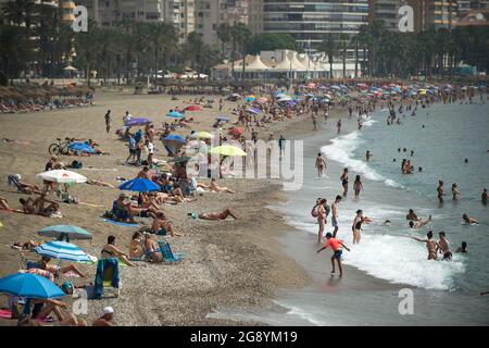 Malaga, Spanien. Juli 2021. Badegäste werden während eines heißen Sommertages inmitten einer Coronavirus-Pandemie am Strand von Malagueta beim Sonnenbaden beobachtet.die staatliche Wetteragentur AEMET sagte, dass die Temperaturen am nächsten Tag in Andalusien mit mehr als 40º Grad in Malaga und anderen Provinzen steigen werden. Viele Badegäste werden erwartet, an den Stränden anzukommen, um sich zu sonnen und die sonnigen Tage zu genießen. Kredit: SOPA Images Limited/Alamy Live Nachrichten Stockfoto