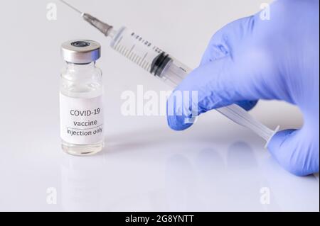 Arzt, der Medikamente aus Coronavirus-Impfstoffröhrchen abzieht Stockfoto
