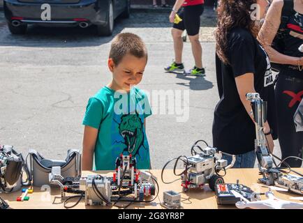 Zaporizhia, Ukraine- 19. Juni 2021: Charity Family Festival: Boy exploring robots at Outdoor modern Technologies Exhibition. Stockfoto