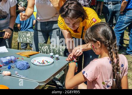 Zaporizhia, Ukraine- 19. Juni 2021: Charity Familienfest: Kinder und Freiwillige, die an Kunst und Handwerk im Freien Workshop teilnehmen, machen Colorfu Stockfoto