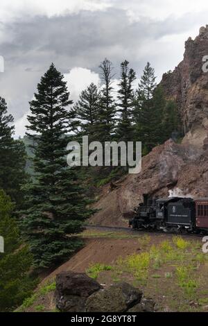 Vertikale Aufnahme der Cumbres und der Toltec Scenic Railroad auf den von Hügeln umgebenen Gleisen Stockfoto