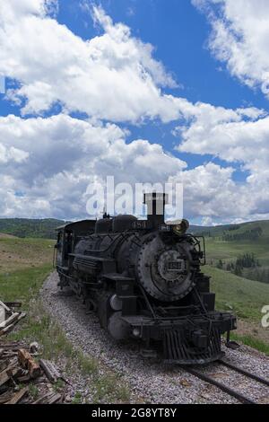 Vertikale Aufnahme der Cumbres und der Toltec Scenic Railroad auf den Gleisen in einem Feld unter bewölktem Himmel Stockfoto