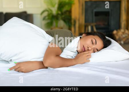 Nahaufnahme einer schlafenden asiatischen Frau. Sie liegt unter Bettdecke - gesundes Schlafkonzept. Stockfoto
