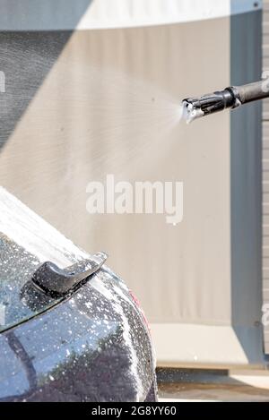 Autowäsche. Der Prozess des Waschens eines Autos mit Aktivschaum unter Druck. Manuelle Autowäsche zur Selbstbedienung. Konzept für die Fahrzeugpflege Stockfoto