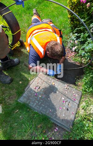 Fremdfirmen, die mit einer Kamera und einer Rolle Glasfaserkabel arbeiten, untersuchen ein verstopftes Kanalablasssystem auf Verstopfung und die Ursache des Problems. VEREINIGTES KÖNIGREICH. (127) Stockfoto