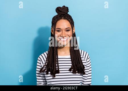 Foto-Porträt eines lächelnden Mädchen mit Dreadlocks Top-Knoten tragen gestreiftes Hemd isoliert pastellblau Hintergrund Stockfoto