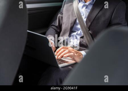 Männlich Profi mit Laptop im Auto Stockfoto