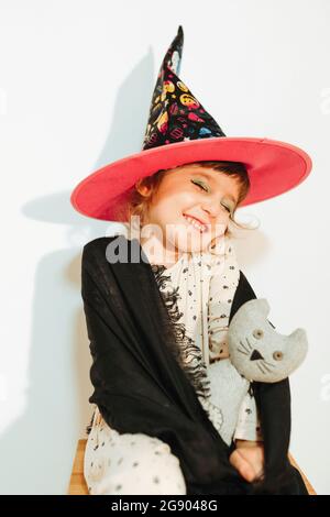 Lächelndes nettes Mädchen als Halloween Hexe gekleidet Stockfoto