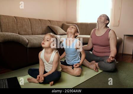 Sohn und Tochter praktizieren Yoga mit Mutter zu Hause Stockfoto