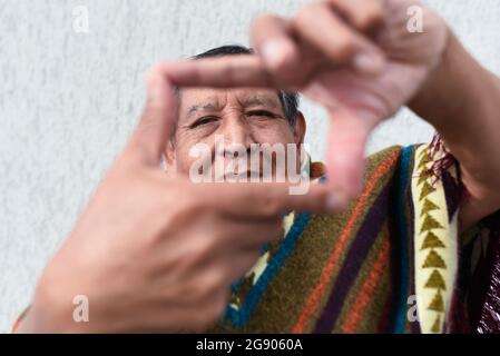 Lächelnder älterer Mann, der Fingerrahmen macht Stockfoto