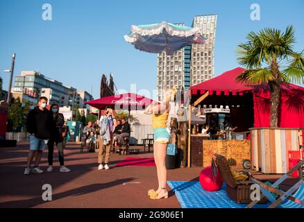 Hamburg, Deutschland. Juli 2021. Die Künstlerin Holiday on Delay tritt beim Spielbuden Festival auf dem Spielbudenplatz auf der Reeperbahn auf und balanciert einen Sonnenschirm am Kinn. Quelle: Daniel Bockwoldt/dpa/Alamy Live News Stockfoto