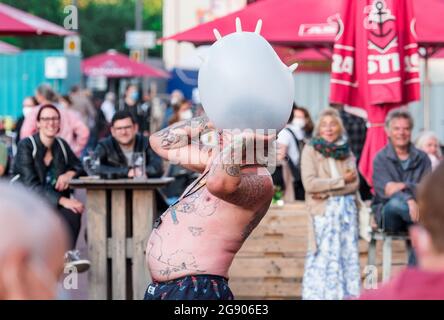 Hamburg, Deutschland. Juli 2021. Der Künstler Roc-IT tritt beim Spielbuden Festival auf dem Spielbudenplatz auf der Reeperbahn auf und bläst mit der Nase einen Ballon in die Luft. Quelle: Daniel Bockwoldt/dpa/Alamy Live News Stockfoto