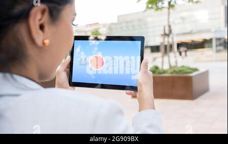 Geschäftsfrau beobachtet Hund auf digitalen Tablet zu Hause Stockfoto