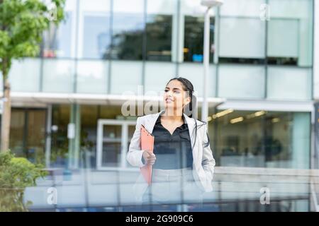Lächelnde Geschäftsfrau mit Laptop in kreisförmiger Ikone Stockfoto