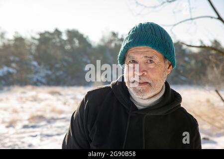 Älterer Mann mit Strickmütze im Winter Stockfoto